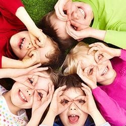 Children lying in the grass smiling.